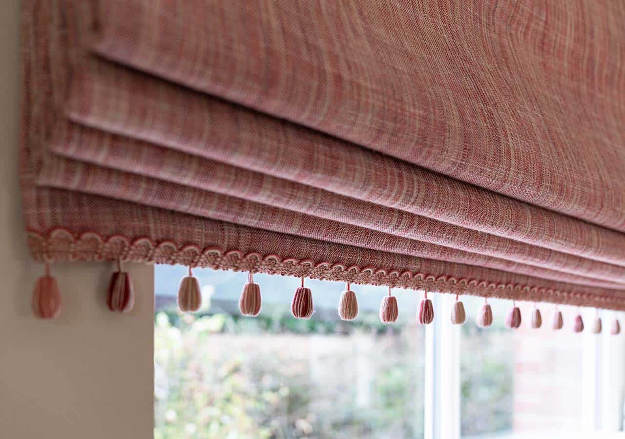 detail of handmade pink roman blind with ornate beading