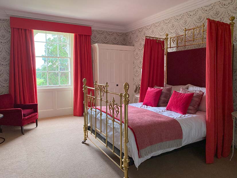 bright pink half tester bed dressing with coordinating skatter cusions